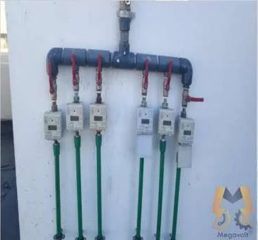 Rooftop water meter manifold with six valves and smart water meters at a building in Deira